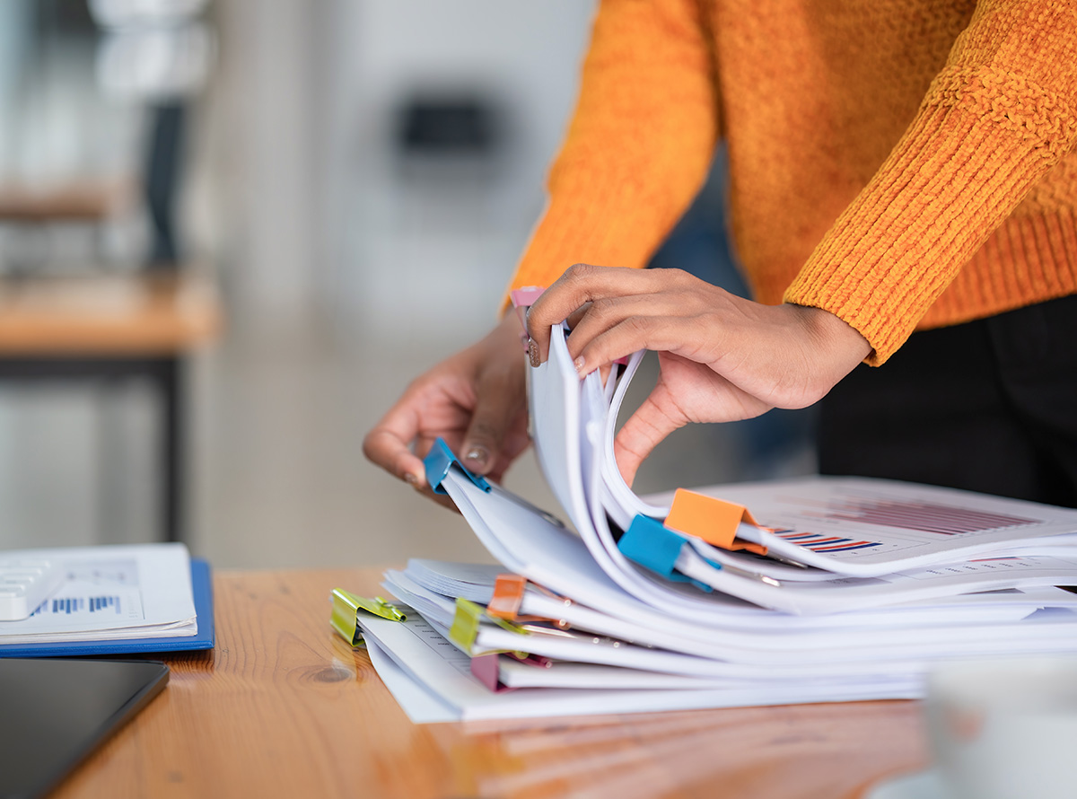 Close-up hand of businesswoman arranging documents on her desk